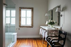 a bathroom with a sink and a mirror at 86 Cannon Historic Inn - Adults Only in Charleston