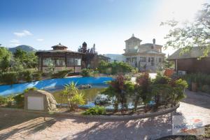 a large house with a pond in front of it at HOLIDAYS MIRANA in Yecla