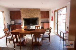 a kitchen with a table and chairs and a fireplace at HOLIDAYS MIRANA in Yecla