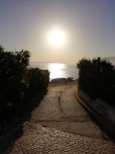 ロウリニャンにあるGrillohouseの空に太陽が輝く海へと続く道