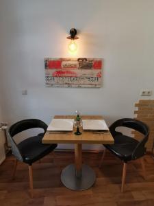 een houten tafel met 2 stoelen en een plafondventilator bij Haus am Eichenwall, Fewo1, Residenz + Ferienwohnungen in Friedland