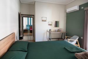 a bedroom with a green bed and a table at Emerald 110m2 entire floor apt steps to city’s heart in Kalamata