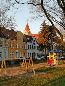 een park met speeltoestellen voor een gebouw bij Haus am Eichenwall, Fewo1, Residenz + Ferienwohnungen in Friedland