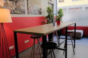 
a room with a table, chairs and a lamp at HelloBCN Youth Hostel Barcelona in Barcelona

