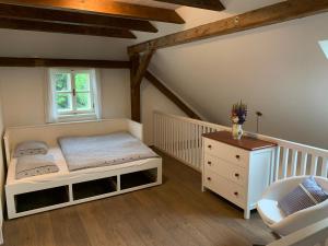 a bedroom with a bed and a dresser and a window at Chalupa Nový Svět na Šumavě in Borová Lada