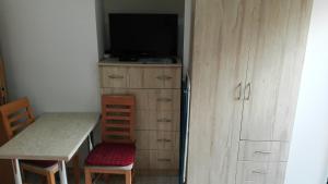 a small kitchen with a table and a tv and a table and a desk at Ubytovanie v sukromi Haragova in Bojnice