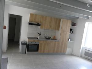 - une cuisine avec des placards en bois dans l'établissement Grand gite du Puy Lambert, à La Flocellière