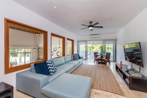 uma sala de estar com um sofá azul e uma televisão em Unique Private Villa with Pools and Golf Cart em La Romana