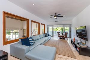 a living room with a blue couch and a tv at Unique Private Villa with Pools and Golf Cart in La Romana