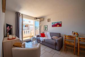 ein Wohnzimmer mit einem Sofa und einem Fenster in der Unterkunft T2 en hypercentre -parking privé-clim-proche plage in Sainte-Maxime