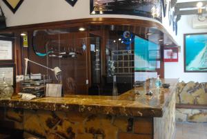 a bar in a restaurant with a glass wall at Hostal Costa De La Luz in Conil de la Frontera