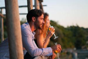 a man and woman sitting next to each other drinking wine at Hotel Il Girasole in Anacapri