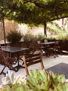 um grupo de mesas e cadeiras sob um guarda-sol em L’Auberge du Sombral em Saint-Cirq-Lapopie