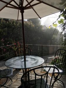 a table and chairs under an umbrella on a patio at L’Auberge du Sombral in Saint-Cirq-Lapopie