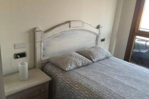 a bedroom with a bed with a large headboard at APARTAMENTO 1ºLINEA PLAYA PONIENTE in Gijón
