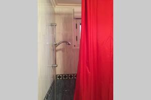a shower with a red curtain in a bathroom at APARTAMENTO 1ºLINEA PLAYA PONIENTE in Gijón