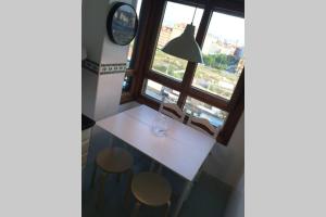 a room with a table and two chairs and a window at APARTAMENTO 1ºLINEA PLAYA PONIENTE in Gijón +30 photos