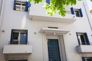 biały budynek z niebieskimi oknami i drzwiami w obiekcie Bentzi...Boutique Apartment in Pangrati, Superior Suite (2) for 4 guests w Atenach
