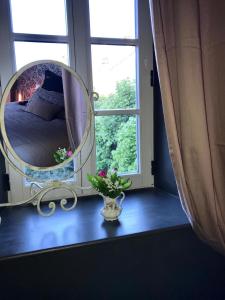 a bedroom with a large mirror and a vase with flowers at Perlépampille in Dinan