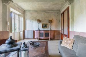 sala de estar con sofá y mesa en Villa Liberty 1927 heated pool, 2 miles Lucca, en Capannori