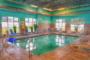 - une piscine avec des chaises dans l'établissement Baymont by Wyndham Grand Rapids N/Walker, à Grand Rapids