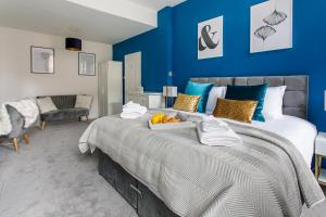 a bedroom with a large bed with blue walls at Stylish Apartment in the heart of Newcastle centre in Newcastle upon Tyne