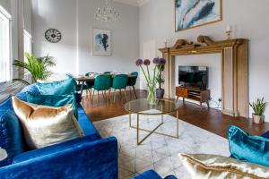 a living room with a blue couch and a table at Stylish Apartment in the heart of Newcastle centre in Newcastle upon Tyne