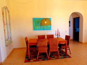 uma sala de jantar com uma mesa de madeira e cadeiras em Villa Esmeralda em Albufeira