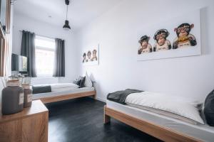 ein Schlafzimmer mit zwei Betten und Bildern an der Wand in der Unterkunft Sleep Point - Self Check in Hotel in Bremen
