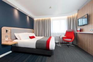 Pokój hotelowy z łóżkiem i czerwonym krzesłem w obiekcie Holiday Inn Express London-Hammersmith, an IHG Hotel w Londynie