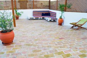 Un patio con un sofá y una silla y plantas. en Casa aOrta, en Faro