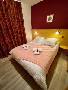 a bedroom with a large bed with two towels on it at Hôtel Bel'Air in Jausiers