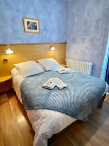 1 dormitorio con 1 cama con 2 toallas en Hôtel Bel'Air en Jausiers