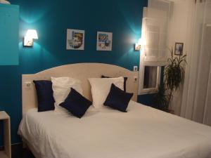 a bedroom with a white bed with blue walls at Entre montagnes et lac in Armoy