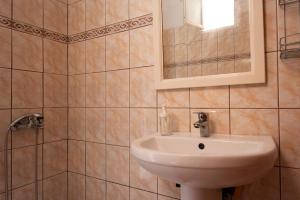 uma casa de banho com um lavatório e um espelho em Janakis Apartments em Himare