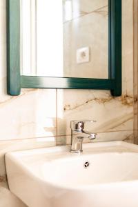 a bathroom sink with a mirror and a sink at Janakis Garden Livadi Beach in (( Spile ))