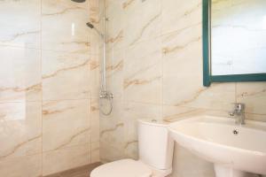 a bathroom with a toilet and a sink and a shower at Janakis Garden Livadi Beach in (( Spile ))
