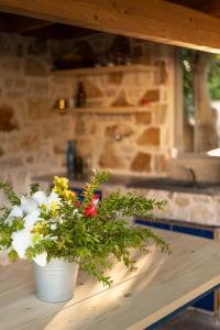 two buckets of flowers sitting on a table at Janakis Garden Livadi Beach in (( Spile ))