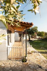 a porch of a house with a wooden roof at Janakis Garden Livadi Beach in (( Spile ))