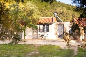 a small white house with a table in front of it at Janakis Garden Livadi Beach in (( Spile ))