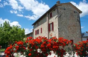 ceglany budynek z czerwonymi kwiatami przed nim w obiekcie Casa Donella B&B w mieście Gricignano