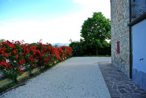 un vialetto con fiori rossi accanto a un edificio di Casa Donella B&B a Gricignano