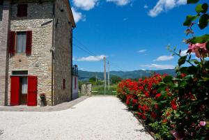 budynek z czerwonymi drzwiami obok kwiatów w obiekcie Casa Donella B&B w mieście Gricignano