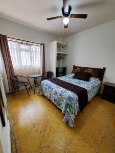 Hotel Catalina في اوريزابا: غرفة نوم بسرير ومروحة سقف