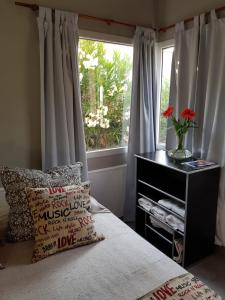 a bedroom with a window and a bed with a pillow at Cabaña Loft La Ribera in Maipú