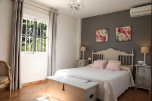 sypialnia z łóżkiem z różowymi poduszkami i oknem w obiekcie Villa las Tinajas Luxury w mieście Nerja
