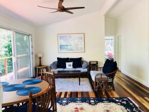a living room with a couch and a ceiling fan at Billa Bush Cottage in Point Lookout