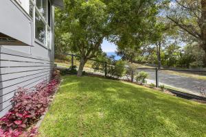 einen Hof mit rosa Blumen an der Seite eines Hauses in der Unterkunft Amalfi in Point Lookout