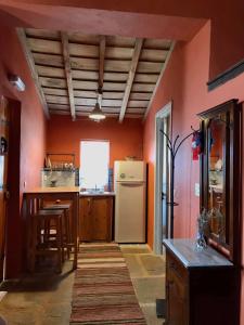 uma cozinha com paredes cor de laranja e um frigorífico branco em Toumba Eco Farm Guesthouses em Plomari