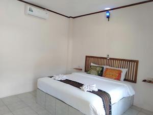 a bedroom with a bed with white sheets and bows at Jeri Home Stay in Kuta Lombok